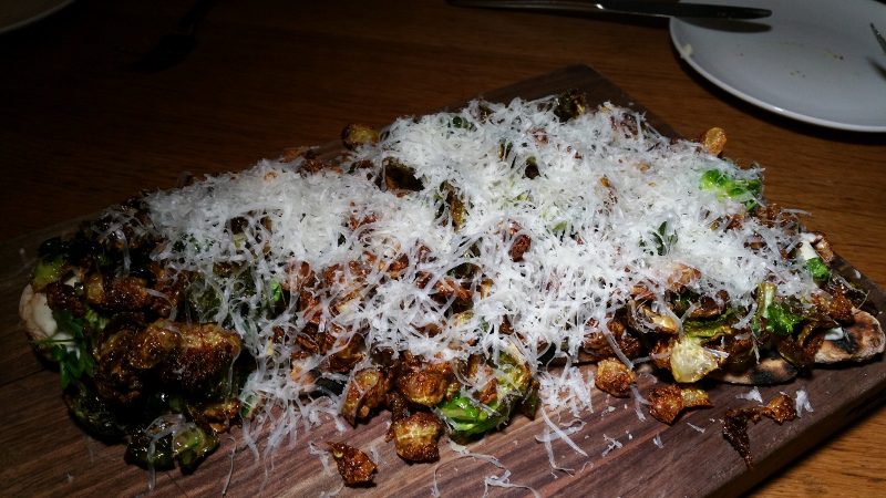 Grilled Flatbread with brussels sprouts, buttermilk, sheep's milk cheese and crispy pig ear